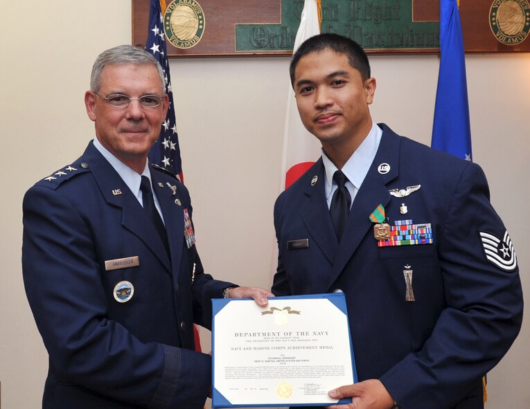 U.S. Air Force Lt. Gen. Salvatore Angelella, U.S. Forces Japan and 5th Air Force commander, awards U.S. Air Force Tech. Sgt. Kent Santos, 18th Aeromedical Evacuation Squadron air medical evacuation technician, the Navy and Marine Corps Achievement medal at the Officer’s Club on Kadena Air Base, Japan, July 10, 2013. While exercising at the Risner gym on Kadena Air Base, Japan, Santos, without hesitation, went to the aid of a Patrol Squadron 4-5 sailor who was suffering an apparent heart attack on April 5, 2013. By his rapid response, expertly administered first aid and sound judgment, Santos, along with U.S. Air Force Staff Sgt. Jesus Sanchez, 18th Aeromedical Evacuation Squadron air medical evacuation technician, undoubtedly saved the sailor’s life. (U.S. Air Force photo by Naoto Anazawa/Released)