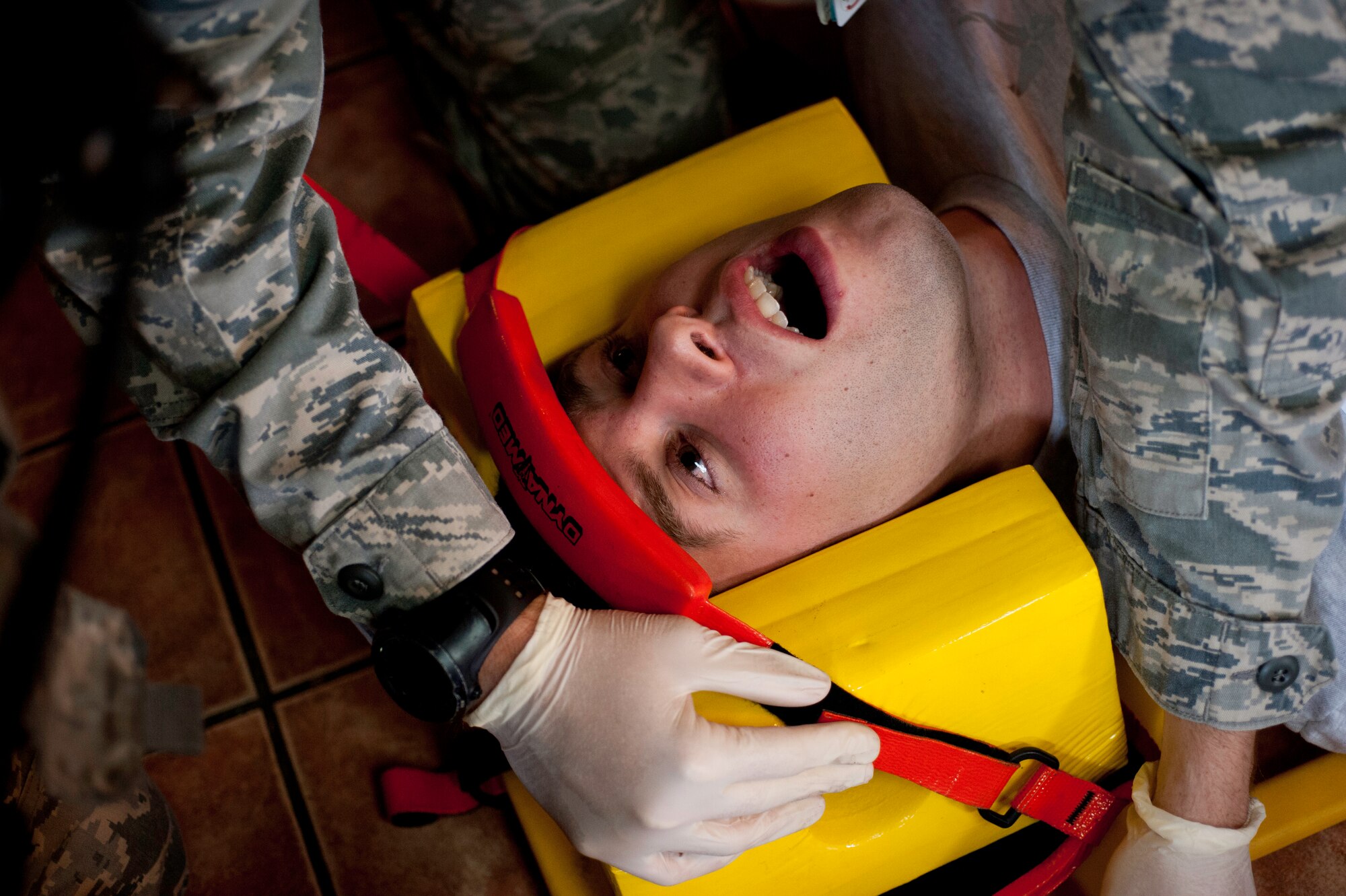 Senior Airman Daniel Nickel, 8th Maintenance Squadron munitions flight operations document controller, screams in “pain” as 8th Medical Group first responders treat him at Kunsan Air Base, Republic of Korea, July 9, 2013. Nickel was a role player during an exercise testing the ability of Kunsan’s first responders. (U.S. Air Force photo by Senior Airman Armando A. Schwier-Morales) 