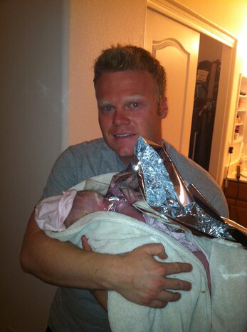 Staff Sgt. Talon Potter, 799th Security Forces Squadron security forces leader, holds his daughter Ella just moments after she was born May 6, 2013. Potter was prompted to deliver his child after a 911 dispatcher notified him that they would not be able to reach the hospital in time. (Courtesy photo)  