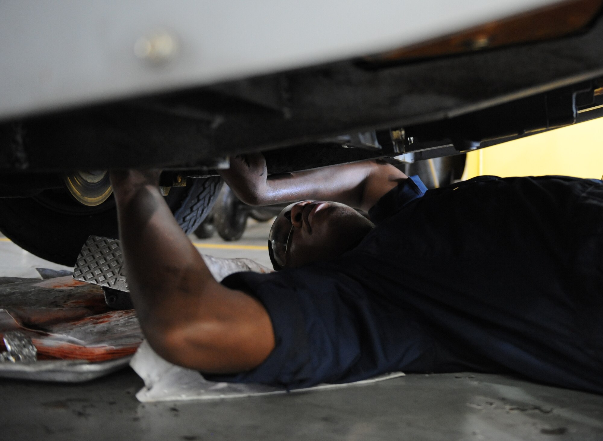 Senior Airman Marcus Smith, 2nd Maintenance Squadron Aerospace Ground Equipment flight, installs a hydraulic line inside a bomb lift on Barksdale Air Force Base, La., July 8, 2013. Because the equipment is aging, new parts need to be modified in order to be installed properly. (U.S. Air Force photo/Airman 1st Class Benjamin Gonsier)  
