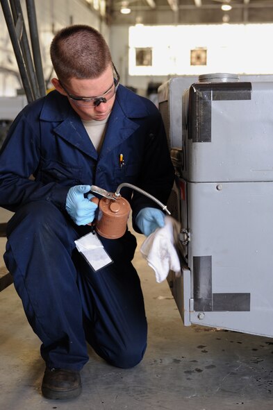 Airman Garrett Jimenez, 2nd Maintenance Squadron Aerospace Ground Equipment flight, lubricates a hinge on a bomb lift on Barksdale Air Force Base, La., July 8, 2013. Parts are lubricated to prevent damage and extend the service life of the component. (U.S. Air Force photo/Airman 1st Class Benjamin Gonsier)