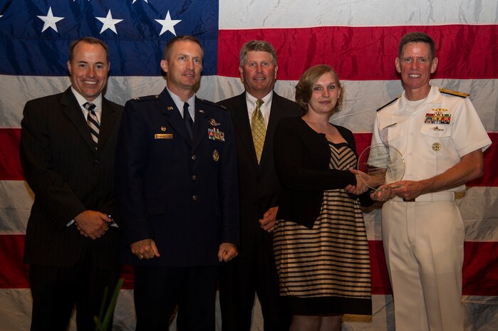 Rear Adm. Richard Breckenridge (right), Undersea Warfare Division director, Col. James J. Fontanella, 315th Airlift Wing commander, presents Evelyn Wilhems the Civilian Employee of the Year award on behalf of her husband Paul Wilhems, June 27, 2013, during the “Salute to the Military” ceremony at the North Charleston Performing Arts Center, North Charleston, S.C. (From left to right) Jon Rudy of General Dynamics Land Systems Force Protection, the Title Sponsor, and Mr. Stuart Whiteside, Charleston Metro Chamber Chairman of the Board, are also pictured here. Paul Wilhems , a 315th Airlift Wing electro environmental apprentice, performs in-shop and flight-line maintenance on 51 assigned C-17 aircraft and their associated components valued at $10.8 billion. Wilhems volunteered nearly 100 hours of his time to community service. (U.S. Air Force photo/Staff Sgt. Rasheen Douglas)