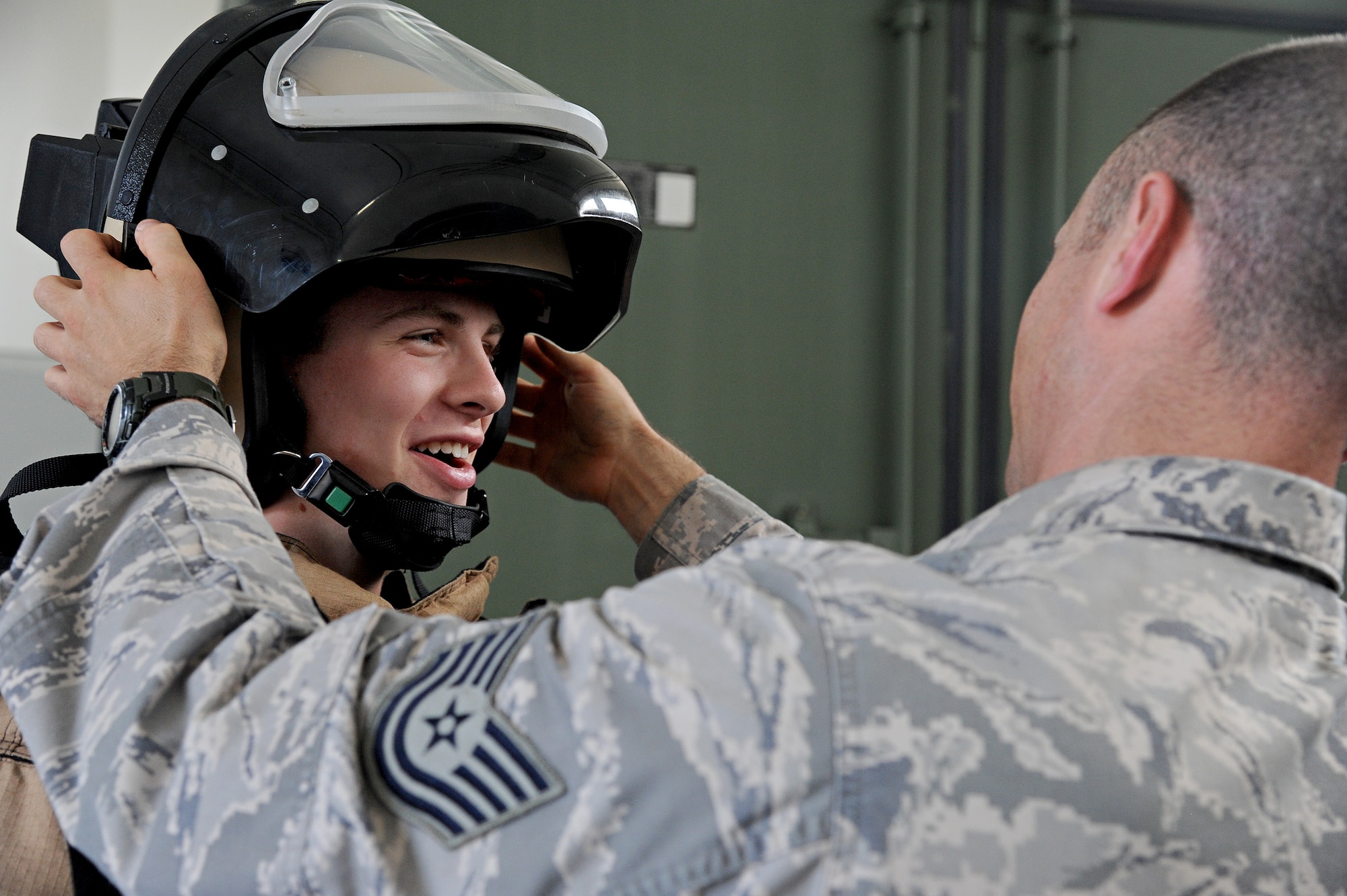 Tech. Sgt. Eric Barger, 375th Civil Engineer Squadron explosive ordnance disposal technician, puts an 80-pound bomb suit on a cadet during a visit from the United States Air Force Academy cadets July 8 at Scott Air Force Base, Ill. The cadets learned about the vigorous training that EOD technicians must go through to become specialists and also got to test their strength by lifting heavy equipment and trying to perform strength exercises while wearing the suit. (U.S. Air Force photo/Airman 1st Class Kristina Forst)