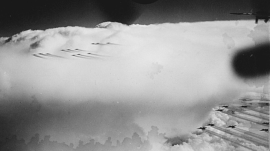 B-17 Bombers from the 91st Bombardment Group fly in formation above the clouds during World War II. The image was taken from the ball turret of a B-17 by Sergeant Joe Harlick, whose uniform and imagery are on display at the Jimmy Doolittle Center on Minot Air Force Base, N.D. (U.S Army Air Corps photo/ Sergeant Joe Harlick)