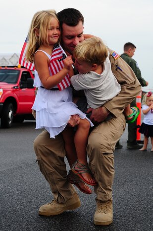 Capt. Rob Beckenhauer, 16th Airlift Squadron director of staff, hugs his children  during the 437th Airlift Wing’s 16th AS redeployment July 2, 2013, at Joint Base Charleston - Air Base, S.C. More than 120 Airmen from the 16th AS returned home from a 60-day deployment to Southwest Asia. Flying the C-17 Globemaster III, crews flew and supported roughly 1,000 sorties, logged more than 2,500 combat flying hours and airlifted more than 36 million pounds of cargo. (U.S. Air Force photo/ Airman 1st Class Chacarra Neal)