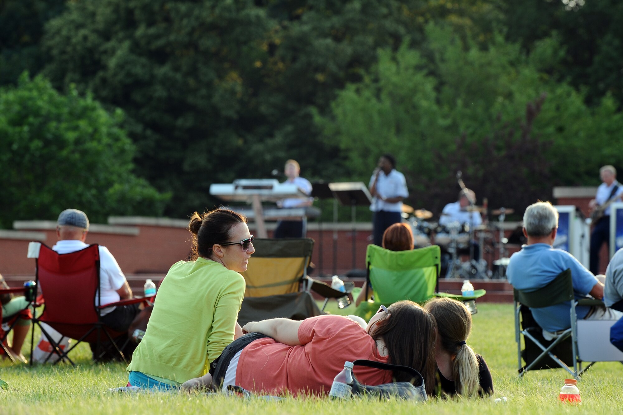 Concert goers relax on blankets and lawn chairs while attending the Heartland of America Band’s free concert series Sundays on Parade held on the historic Parade Grounds on June 30, Offutt Air Force Base, Neb. (U.S. Air Force photo by Josh Plueger/Released)