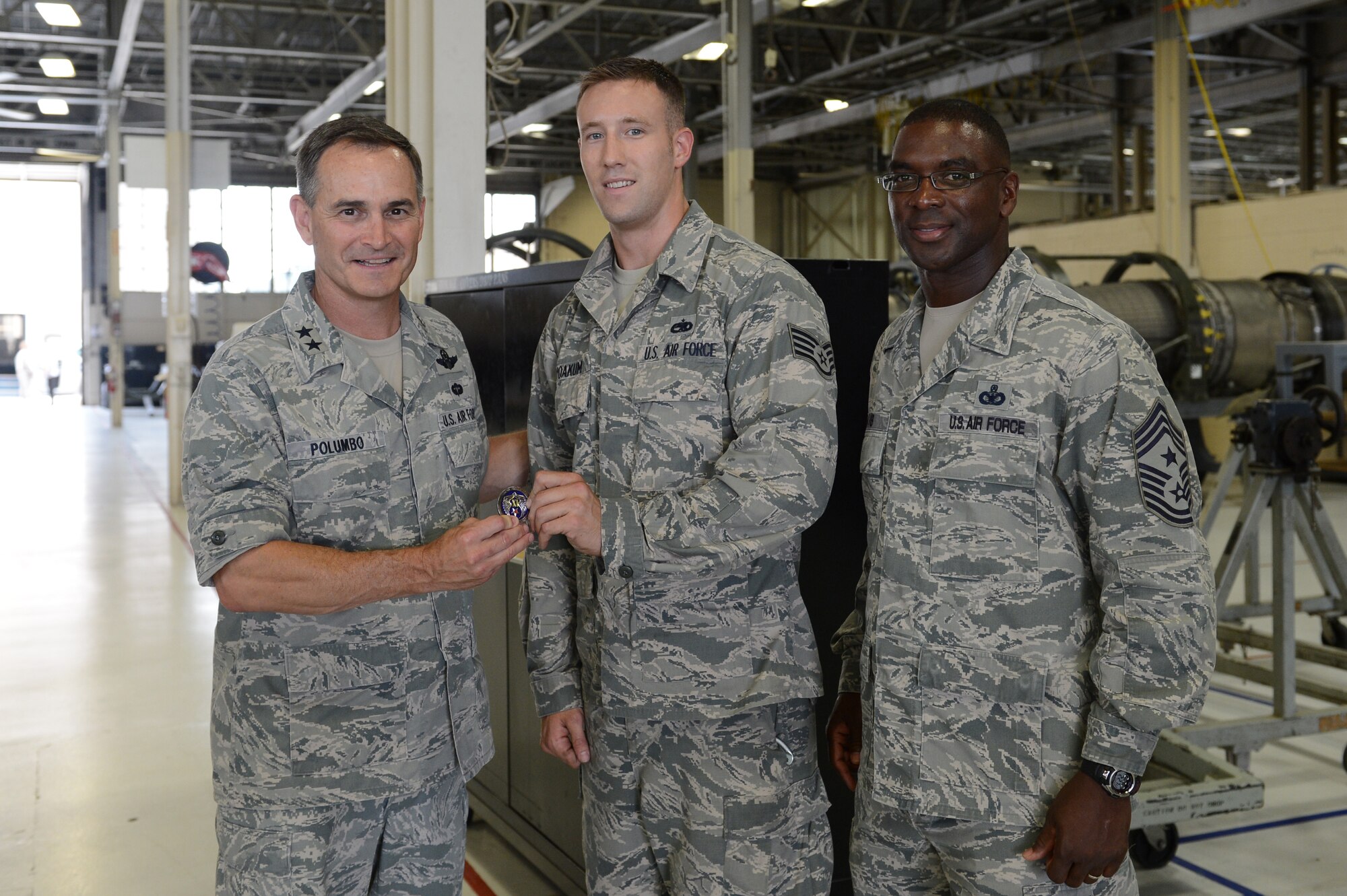 Maj. Gen. Jake Polumbo, 9th Air Force commander, presents Staff Sgt. Derek Yoakum, 20th Component Maintenance Squadron, with his commander’s coin during a tour of 20th Fighter Wing at Shaw Air Force Base, S.C., July 1, 2013. In addition to visiting the 20th CMS, Polumbo also visited other units that compose 20th FW like the 20th Medical Group and the 20th Logistics Readiness Squadron. (U.S. Air Force photo by Airman 1st Class Krystal M. Jeffers/Released)