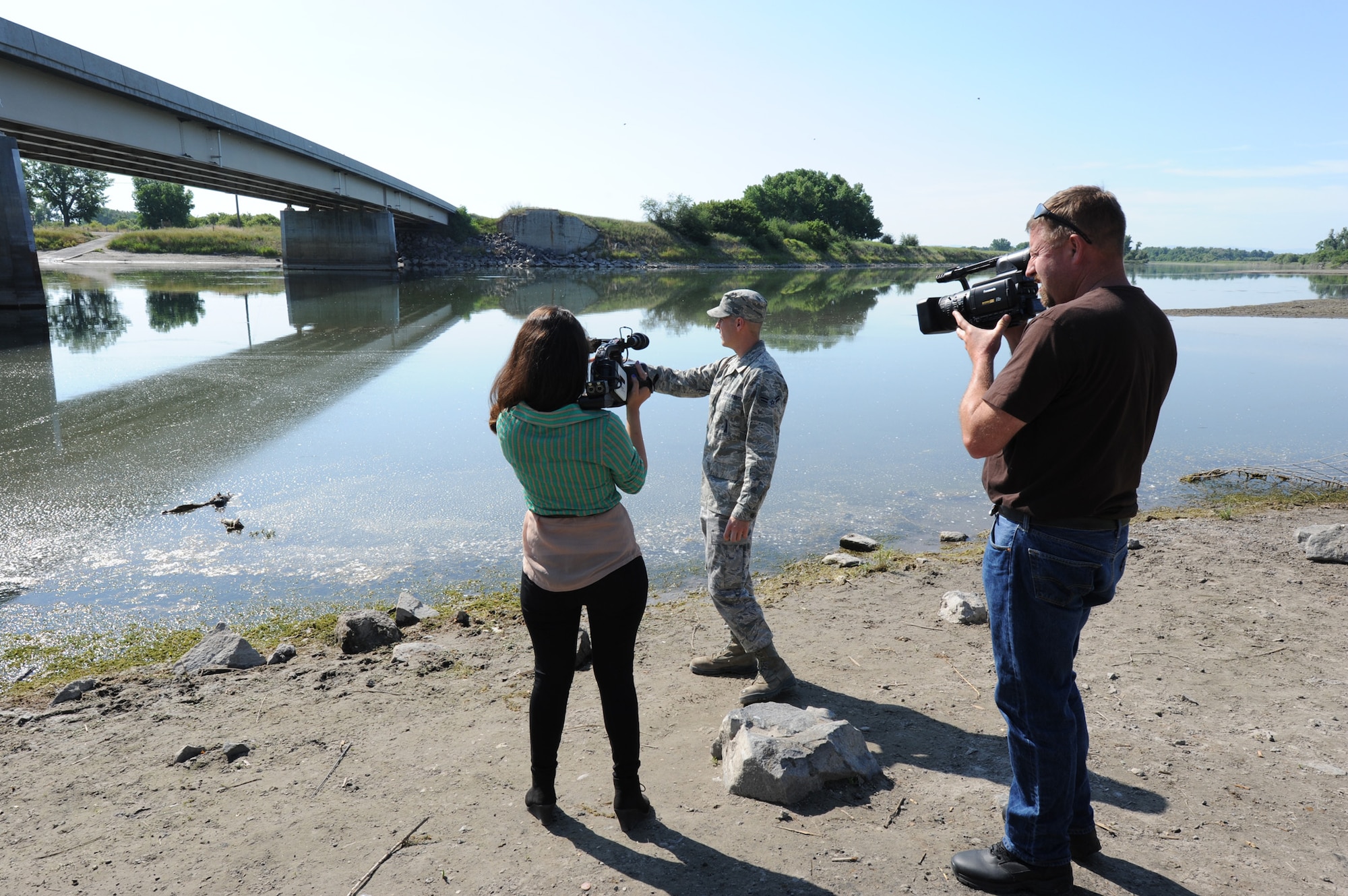 Airman 1st Class Jake Bush, 341st Missile Maintenance Squadron electro-mechanical technician, describes diving into the Missouri River on July 1, rescuing three people underneath the Ulm Bridge. Mayra Castaneda, Great Falls KFBB Channel 5 news reporter, and Beau Wade, 341st Missile Wing Public Affairs videographer, video-taped Bush as he explained the accident. (U.S. Air Force photo/Senior Airman Katrina Heikkinen)