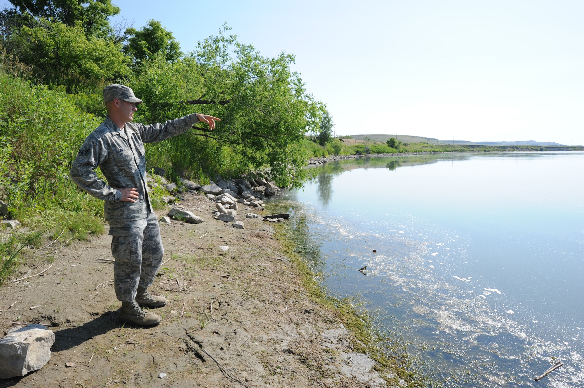 Airman 1st Class Jake Bush, 341st Missile Maintenance Squadron electro-mechanical technician, points at the Missouri River where he rescued three people approximately 150 yards from where he was fishing July 1 in Ulm, Mont. Although one of the individuals died Tuesday night at Benefis Hospital in Great Falls, Mont., Bush utilized refresher skills taught at a CPR course he had taken earlier that day at Malmstrom Air Force Base. (U.S. Air Force photo/Senior Airman Katrina Heikkinen)