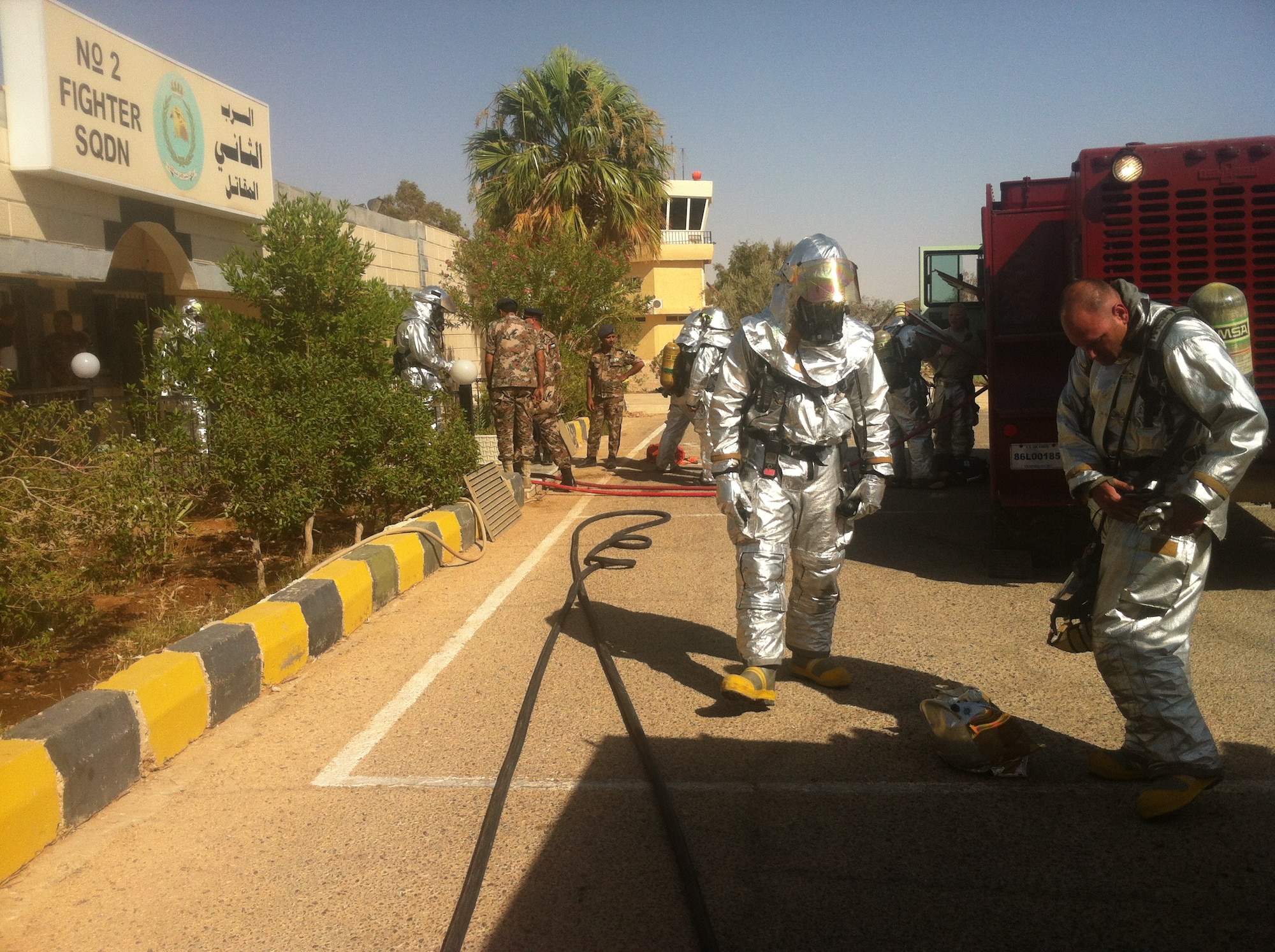The Civil Engineering Quick Strike Force team forward deployed from the Combined Air and Space Operations Center, Southwest Asia, and the Jordanian fire department respond to a fire July 7 in a flying squadron’s life support equipment storage room, Jordan. The Jordanian fire department arrived on scene and requested the assistance of the QST in extinguishing the fire.  The point of origin for the fire was in the air conditioning unit mounted on the wall.  The fire was isolated by the Jordanians and extinguished by the U.S. firefighters, preventing the loss of pilot’s flight suits and helmets. (U.S. Air Force courtesy photo)
