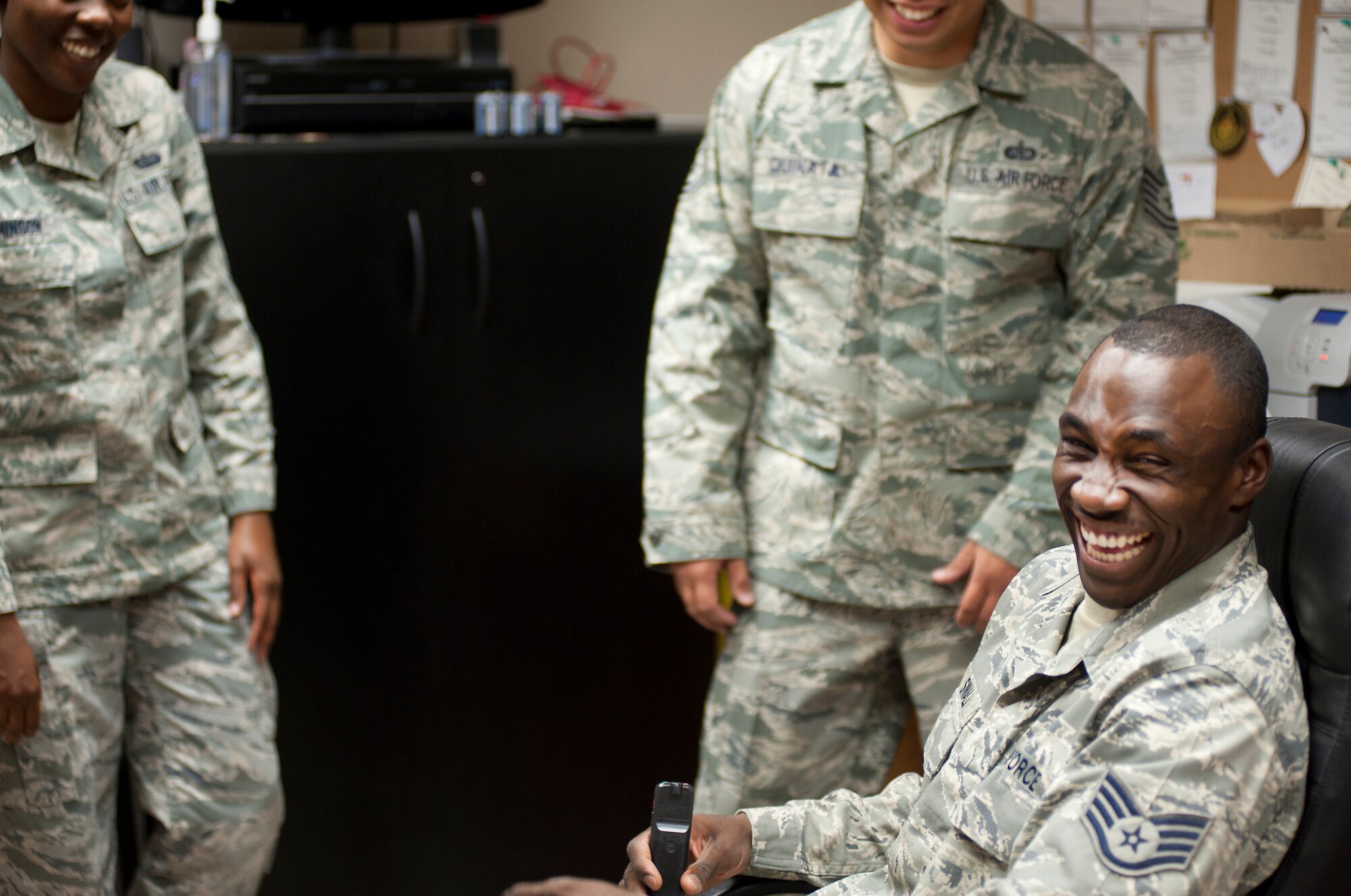 Staff Sgt. Stephen Small shares a joke with colleagues in the protocol office at Transit Center at Manas, Kyrgyzstan, June 18, 2013. He enjoys telling stories about being raised by deaf parents in a family of seven hearing children. He is a member of 376th Air Expeditionary Wing protocol, deployed out of Barksdale, La., and is a native of Norfolk, Va. (U.S. Air Force photo/Staff Sgt. Robert Barnett)