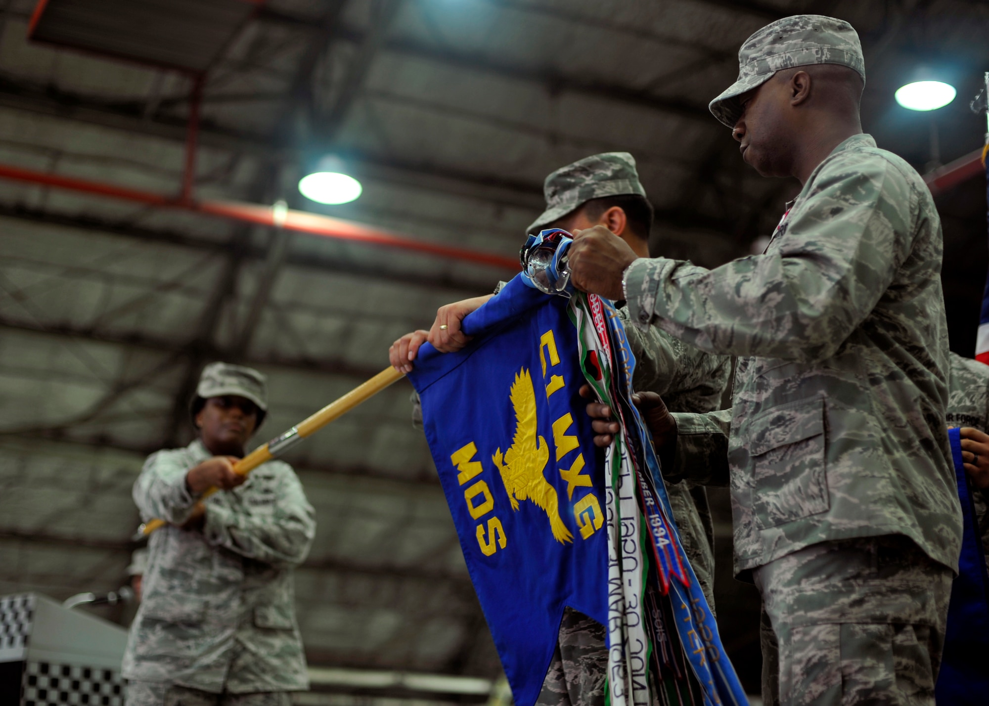 Col. Luis Gallegos, 51st Maintenance Group commander, and Maj. Steven Oliver, 51st Maintenance Operations Squadron commander, furl the 51st MOS flag during the 51st MOS deactivation ceremony at Osan Air Base, Republic of Korea, July 8, 2013. The ceremony served as a final symbol of closure for all those past and present who were part of the 51st MOS. (U.S. Air Force photo/Senior Airman Siuta B. Ika)