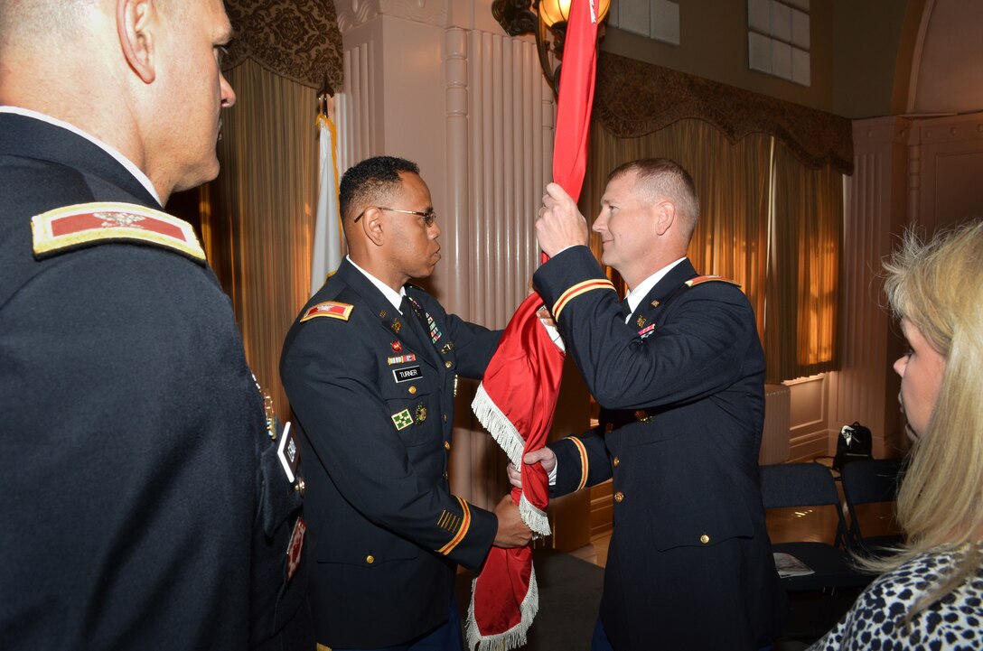 Colonel David Turner (center) passes the Sacramento District’s colors to Col.  Michael J. Farrell during a change of command ceremony for the U.S. Army Corps of Engineers Sacramento District at the Masonic Temple in Sacramento, Calif., July 10, 2013.