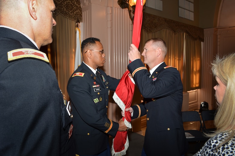 Colonel David Turner (center) passes the Sacramento District’s colors to Col.  Michael J. Farrell during a change of command ceremony for the U.S. Army Corps of Engineers Sacramento District at the Masonic Temple in Sacramento, Calif., July 10, 2013.