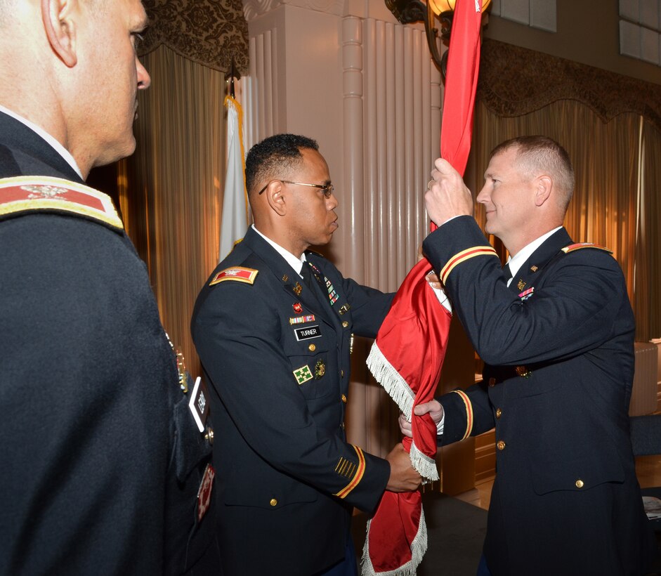Description: Colonel David Turner (center) passes the Sacramento District’s colors to Col. Michael J. Farrell during a change of command ceremony for the U.S. Army Corps of Engineers Sacramento District at the Masonic Temple in Sacramento, Calif., July 10, 2013. 
