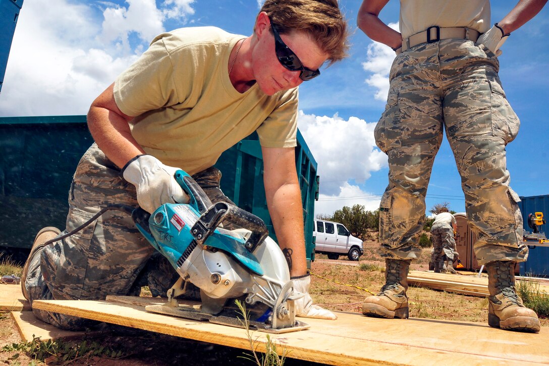 Air Force Staff Sgt. Danielle Nehs cuts lumber for piping support in the crawl space under a hogan during the Innovative Readiness Training's St. Michael's project near Window Rock, Ariz., July 9, 2013. Nehs is a Colorado Guardsman assigned to the 140th Civil Engineering Squadron.