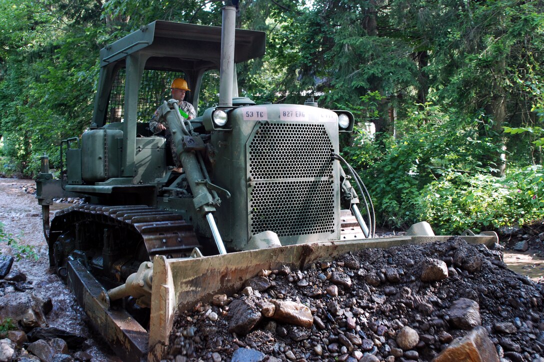Army Staff Sgt. Bryan Starkweather uses a bulldozer to remove flood debris from Fords Creek, German Flatts, N.Y., July 3, 2013. Starkweather is assigned to the New York National Guard's 827th Engineer Company.