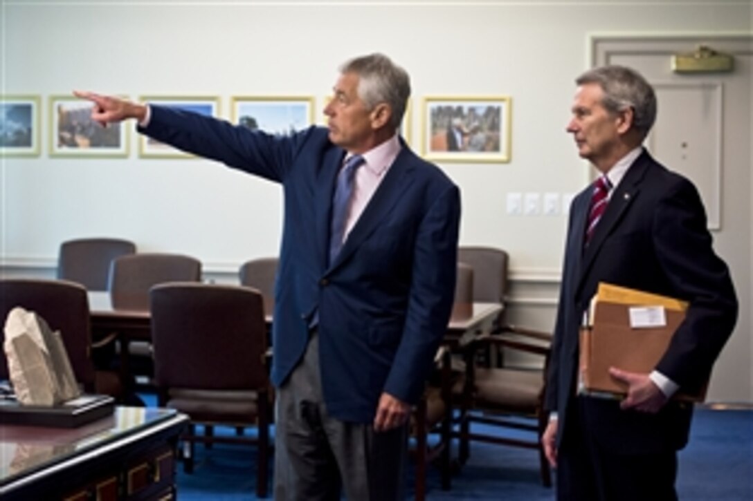 Defense Secretary Chuck Hagel points out changes in the secretary's office during the last six secretaries to U.S. Rep. Walter Jones of North Carolina during a meeting at the Pentagon, July 10, 2013.