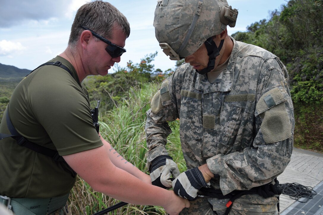 Sgt. Corey A. Jones inspects Sgt. 1st Class Leon P. Nelson’s rappel harness during rappel training June 24 at the Northern Training Area. Nelson joined 10 other soldiers from the 100th Battalion at the jungle leaders’ course for joint training June 2-30. Jones is the chief instructor at the Jungle Warfare Training Center, Camp Gonsalves. Nelson is a scout platoon sergeant with 100th Bn., 442nd Infantry Regiment, 92nd Infantry Division, based in Hawaii. 