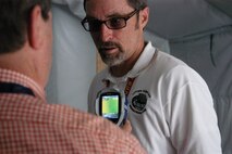 Naval Surface Warfare Center Panama City Division (NSWC PCD) engineers Bob Backus (left) and Ray Sheffield (right) use a hand held thermal imaging device April 26, 2013 to determine heat levels inside a tent being used for energy absorbtion and monitoring research conducted at NSWC PCD.