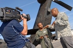 Sgt. Robert McNeil (center) of the 1st Battalion, 111th Aviation Regiment, talks with television host Chris Grundy (right) during filming for an upcoming episode of the DIY Network's show Cool Tools, at the Cecil Commerce Center in Jacksonville, Fla., Monday, Jan. 5, 2008.