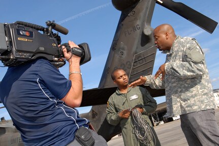 Sgt. Robert McNeil (center) of the 1st Battalion, 111th Aviation Regiment, talks with television host Chris Grundy (right) during filming for an upcoming episode of the DIY Network's show Cool Tools, at the Cecil Commerce Center in Jacksonville, Fla., Monday, Jan. 5, 2008.