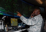 Staff Sgt. Jose Grimes, search and rescue duty officer with the Air Force Rescue Coordination Center at Tyndall Air Force Base, Fla., monitors the radar as he coordinates with another agency during a SAR mission. Sergeant Grimes played a critical role in locating a downed aircraft March 7 near the Canadian border in Maine and coordinating bi-national assets to rescue the aircrew member who survived.

