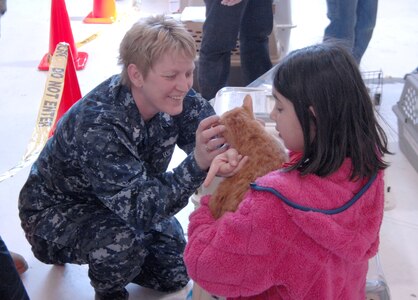 Petty Officer 1st Class Laurie Roods, Navy Operational Support Center Denver, helps Gloria Loveday find her cat, Maggie, after landing at Denver International Airport March 24. Members of all four military branches are working in support of the aerial port of debarkation at DIA as part of Operation Pacific Passage. DIA began receiving military dependents March 24, joining Seattle-Tacoma International Airport, Wash., and Travis Air Force Base, Calif. as points of debarkation for military dependents leaving Japan following the March 11 earthquake and tsunami. 

