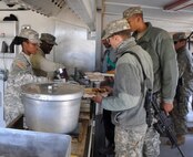 Pfc. Tamika Terry, cook, left, serves lunch at containerized kitchen facility to the 1st Squadron, 13th Cavalry Regiment Soldiers. The squadron deployed to Arizona with all its support elements and conducted concurrent weapons training, tested logistical capabilities, performed maintenance functions, and practiced their unit emergency-response plans. 

