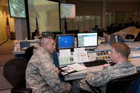 Maj. Herman Suarez, (left), logistics officer on the Joint Task Force - Space Transportation team, discusses JTF team requirements with Maj. Normand Burroughs, team director of communications prior to the final launch of Space Shuttle Discovery Feb. 24, 2011. 

