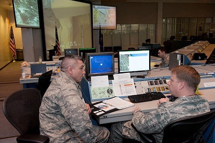 Maj. Herman Suarez, (left), logistics officer on the Joint Task Force - Space Transportation team, discusses JTF team requirements with Maj. Normand Burroughs, team director of communications prior to the final launch of Space Shuttle Discovery Feb. 24, 2011. 

