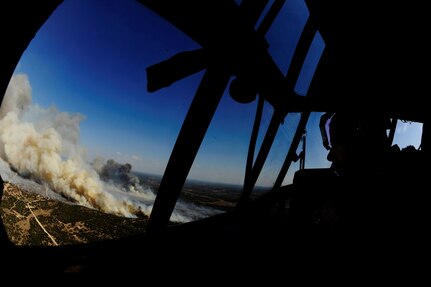 U.S. Air Force Lt. Col. Greg Ervin, 115th Airlift Squadron, California Air National Guard, surveys the Oasis wildfire as they prepare to dispense fire retardant to assist fire fighting efforts in West Texas, April 26, 2011.  Lt. Col. Ervin is a C-130J Hercules pilot and is trained to fly with the Modular Airborne Firefighting System installed in order to aid in the firefighting efforts.  (U.S. Air Force Photo/Staff Sgt. Eric Harris)