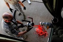 U.S. Air Force Senior Master Sgt. Robert Barry, 146th Aircraft Maintenance Squadron, California Air National Guard, disconnects the fire retardant fill hose from the Modular Airborne Firefighting System(MAFFS) installed on a C-130J Hercules during firefighting operations at Dyess Air Force Base, Texas, April 26, 2011.  MAFFS is capable of dispensing 3,000 gallons of water or fire retardant in under 5 seconds.  Wildfires have spread across various parts of Texas and have burned more than 1,000 square miles of land.  (U.S. Air Force Photo/Staff Sgt. Eric Harris)