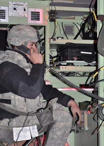 Pfc. Michael Yaeklis, an Air Defense Tactical Operations Center Enhanced Operator-Maintainer, working inside a Sentinel radar air defense control center, conducts preliminary communications during a homeland security support mission executed in support of the U.S. Border Patrol, Tucson Sector. 

