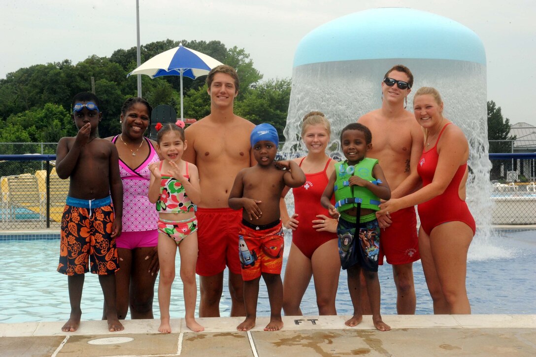 Children with the Exceptional Family Member Program; Monique O’Neil, EFMP manager, water safety instructors; and Lindsay Payne, aquatics director at the Quantico 50-meter pool, pose for a picture after a water safety class aboard Marine Corps Base Quantico on July 9, 2013. Many of the children who participated, swam for the first time during this class.
