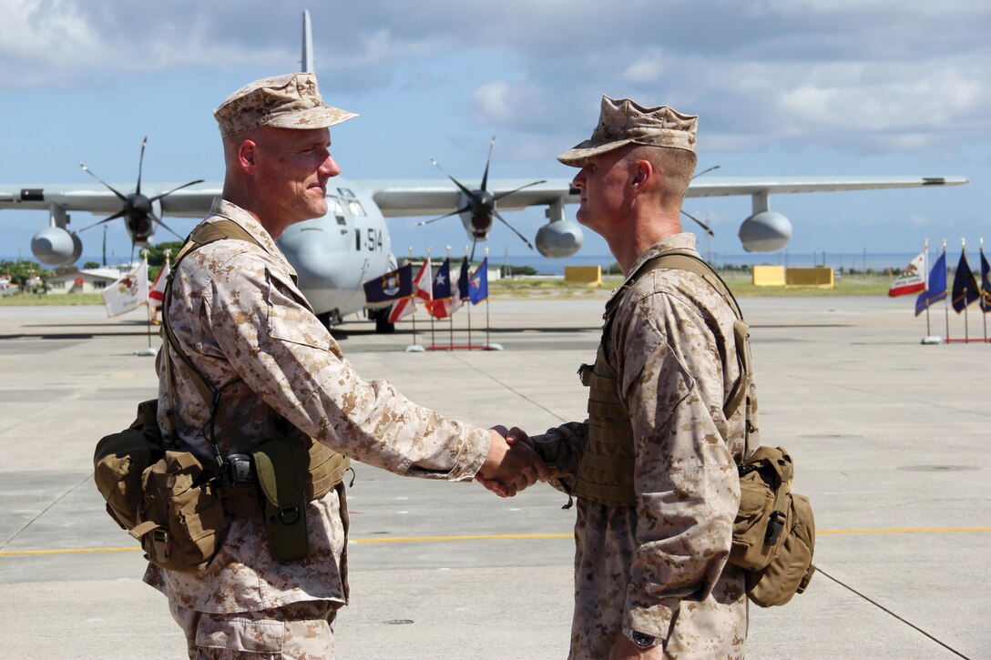 Maj. Gen. Christopher S. Owens, left, and Brig. Gen. Steven R. Rudder shake hands after the 1st Marine Aircraft Wing change of command ceremony July 9 at Marine Corps Air Station Futenma. Rudder assumed command of the 1st MAW, III Marine Expeditionary Force, from Owens. Rudder was the legislative assistant to the commandant of the Marine Corps, and Owens will be the commanding general of U.S. Marine Corps Forces Korea and the assistant chief of staff, C/J-5, plans and operations, Combined Forces Command, U.S. Forces Korea. Photo by Lance Cpl. Donald T. Peterson