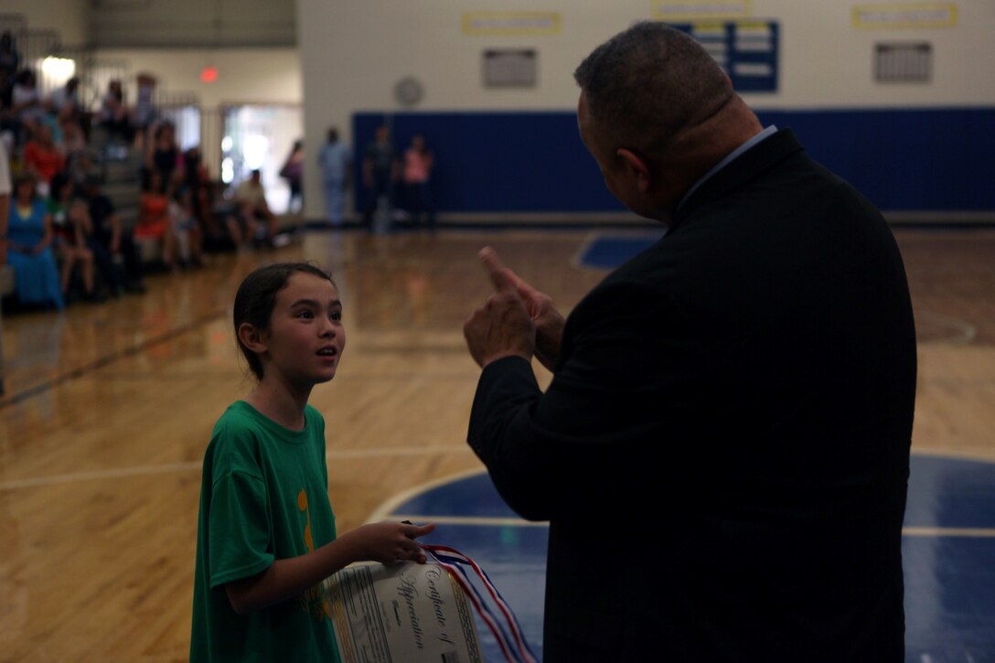 Aldridge A. Boone, Camp Lejeune district superintendent, tells a Hoops-N-Dreams participant she did well during the Hoops-N-Dreams recognition banquet at Brewster Middle School gymnasium aboard Marine Corps Base Camp Lejeune, May 17.