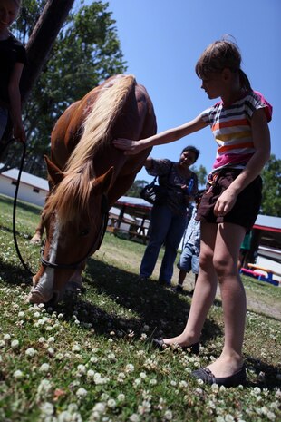 An Exceptional Family Member Program child pets a Scarlet and Gold Riding Club aboard Marine Corps Base Camp Lejeune, May 15. The SGRC staff brought out the horses for a sensory based science class.