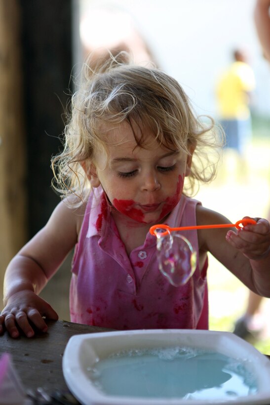 An Exceptional Family Member Program child blows bubbles as part of a science class at the Scarlet and Gold Riding Club aboard Marine Corps Base Camp Lejeune, May 15. More than 30 EFMP adults and children expanded their senses through touch, sight, sounds and smells during the class.