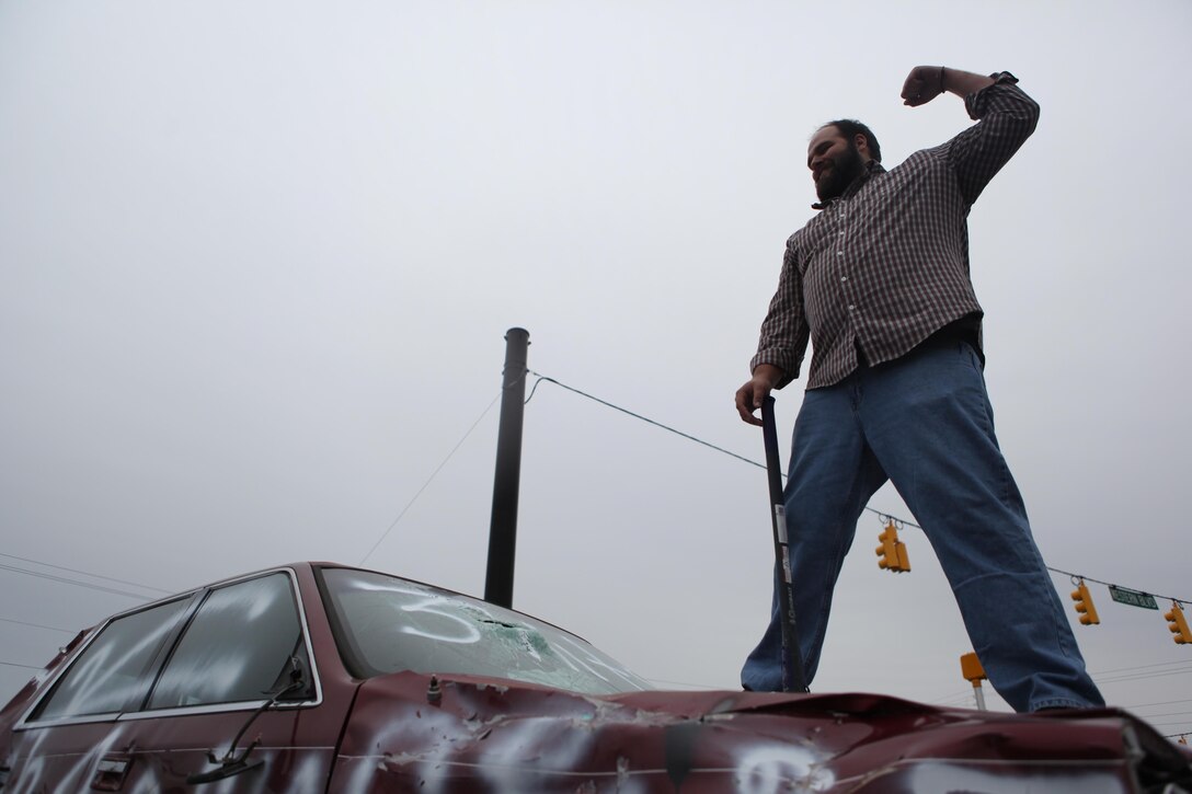 Kristian V. Solberg, car show judge, poses after smashing the windshield of a demolished car during the V Foundation car show in Jacksonville, N.C., March 23.