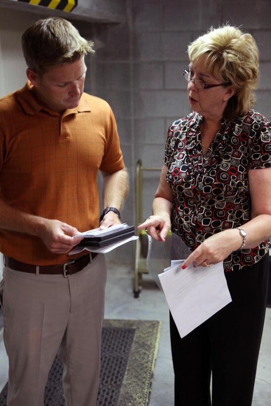 Harold Napier, a realty specialist with Marine Corps Installations East-Marine Corps Base Camp Lejeune Installation Development Division, and Melanie Sheldon, a child of former Camp Lejeune land owners, talk about the research Sheldon and her family have done and stored onto CDs and DVDs while visiting the public works office aboard Marine Corps Base Camp Lejeune, June 27. Five children of former land owners and their families have compiled photos and information about the former land owners and their properties since 2005. The women visited the public works office records vault to research the land's history more and share information with Napier. A reunion for former Camp Lejeune land owner's and their descendants is scheduled for the first Sunday in October at the Staff Noncommissioned Officer's Club aboard base. For more information about the land owners, visit www.marinebasehomes.smugmug.com.