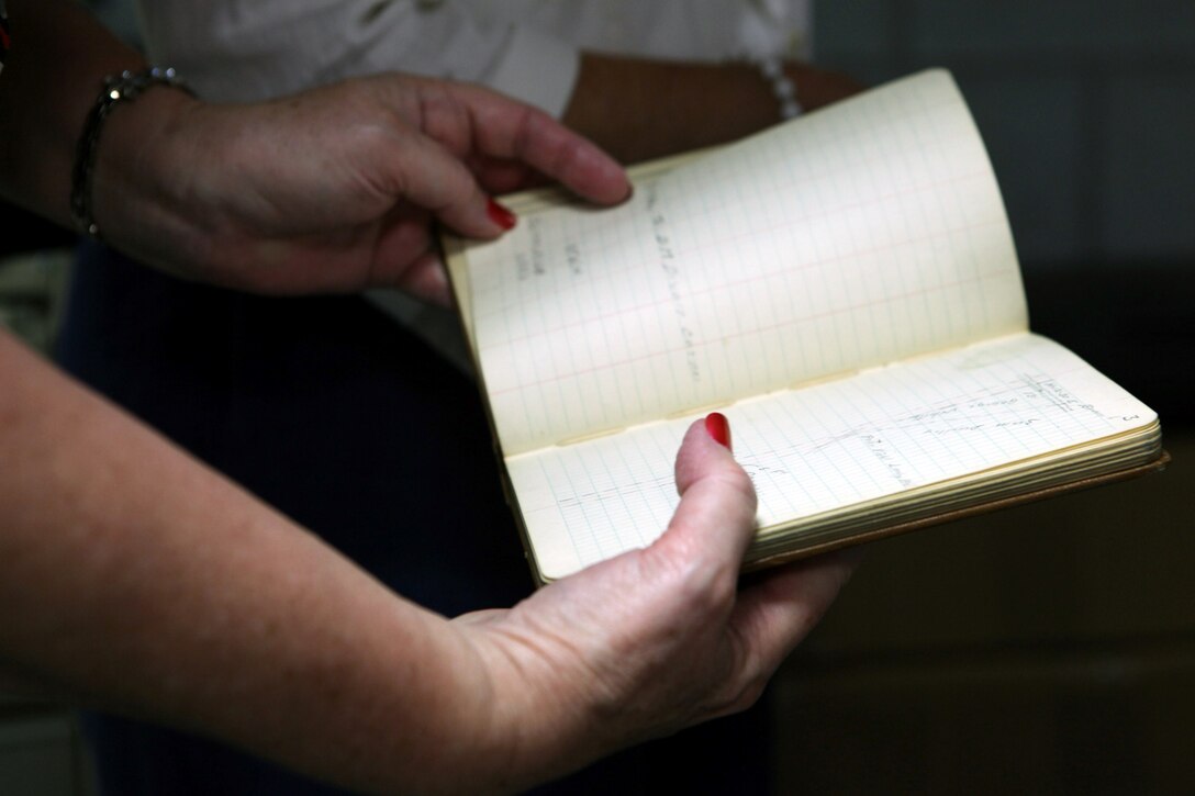 Melanie Sheldon, a child of former Camp Lejeune land owners, holds a record book while visiting the public works office aboard Marine Corps Base Camp Lejeune, June 27. Five children of former land owners and their families have compiled photos and information about the former land owners and their properties since 2005. The women visited the public works office records vault to research the land's history more and share information with Harold Napier, a realty specialist with Marine Corps Installations East-Marine Corps Base Camp Lejeune Installation Development Division. A reunion for former Camp Lejeune land owner's and their descendants is scheduled for the first Sunday in October at the Staff Noncommissioned Officer's Club aboard base. For more information about the land owners, visit www.marinebasehomes.smugmug.com.