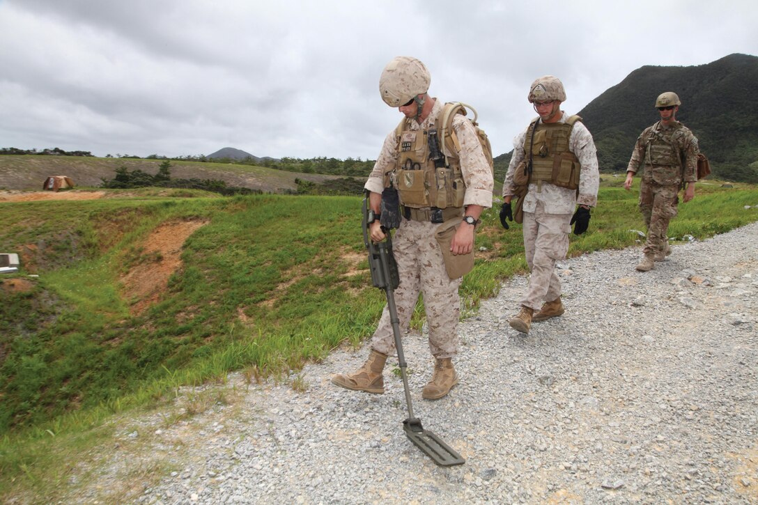 Marines search the surrounding area of a mock blast site June 26 at Camp Schwab. The training gave the Marines of 3rd Explosive Ordnance Disposal Company an opportunity to apply post-blast analysis and site survey techniques in a mock tactical environment. 3rd EOD Co. is part of 9th Engineer Support Battalion, 3rd Marine Logistics Group, III Marine Expeditionary Force. Photo by Lance Cpl. Anne K. Henry