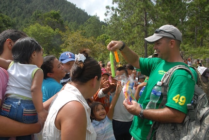 Master Sgt. Steven Fadden, J4 maintenance noncommissioned officer in charge, hands out ice-pops to children during the June 29, 2013, Chapel Hike. More than 100 volunteers from JTF-Bravo gathered together for the bi-monthly Chapel Hike to deliver 120 bags of groceries and supplies to 86 families.