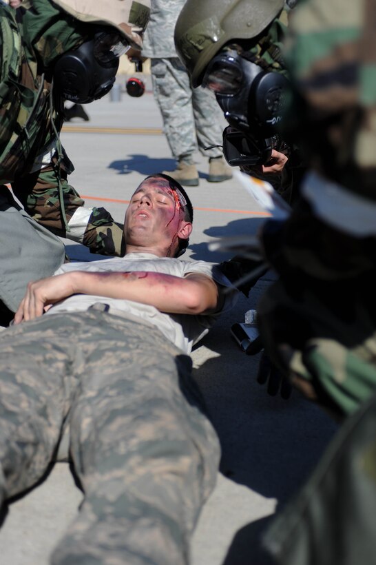 Airmen assigned to the 28th Aircraft Maintenance Squadron perform self-aid and buddy care on a simulated injured Airman during the phase II segment of an operational readiness exercise at Ellsworth Air Force Base, S.D., July 11, 2013. OREs are designed to prepare and train airmen for real-world contingencies in a deployed environment (U.S. Air Force photo by Airman 1st Class Rebecca Imwalle/Released)
