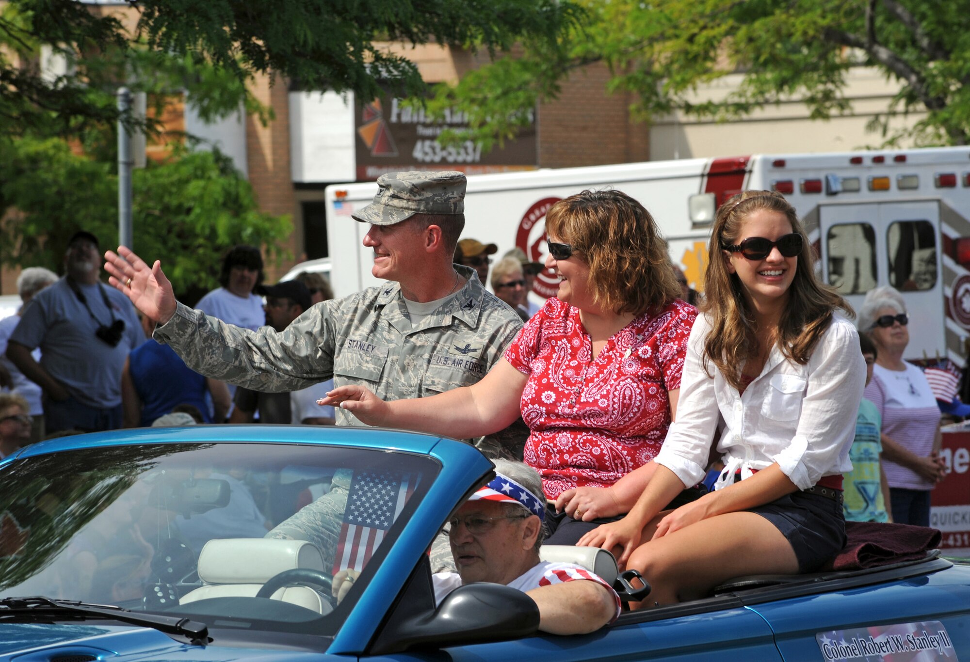 Col. Robert Stanley, 341st Missile Wing commander; wife, Cheryl; and daughter, Beth, wave to onlookers during the Great Falls, Mont., Independence Day Parade. This marked the first parade Stanley has participated in as commander. (U.S. Air Force photo/Staff Sgt. R.J. Biermann)