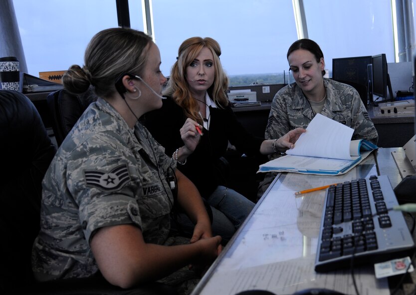 Tracy Brittan, center, 2nd Operations Support Squadron watch supervisor, discusses training records with Staff Sgts. Katelyn Vargas and Nicole Depew, 2nd OSS watch supervisors, on Barksdale Air Force Base, La., July 11, 2013. Airmen begin a year-long training process as watch supervisors once they attain the rank of Staff Sergeant, enabling them to supervise all positions within the control tower, separate arrivals and departures and provide advice in unsafe situations. (U.S. Air Force photo/Airman 1st Class Andrew Moua)