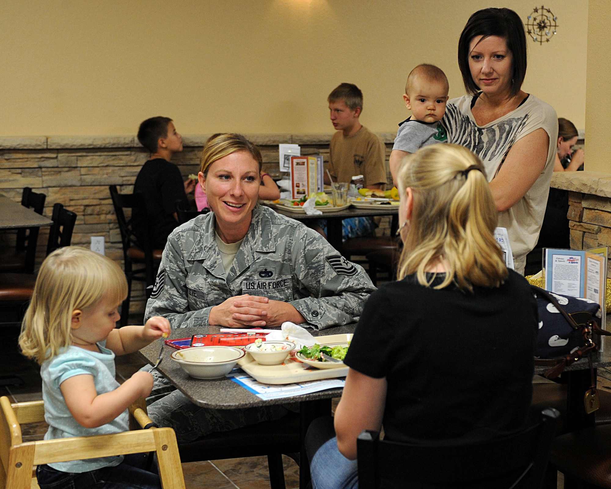 U.S. Air Force Tech. Sgt. Christa Yazzie, 355th Force Support Squadron, Airman & Family Readiness Center, talks with family members of deployed Airmen during the Deployed Spouses’ Dinner at Davis-Monthan Air Force Base, Ariz., July 10, 2013. The dinner is held on the first Wednesday of every month unless that day falls on our close to a holiday. (U.S. Air Force photo by Senior Airman Timothy Moore/Released)