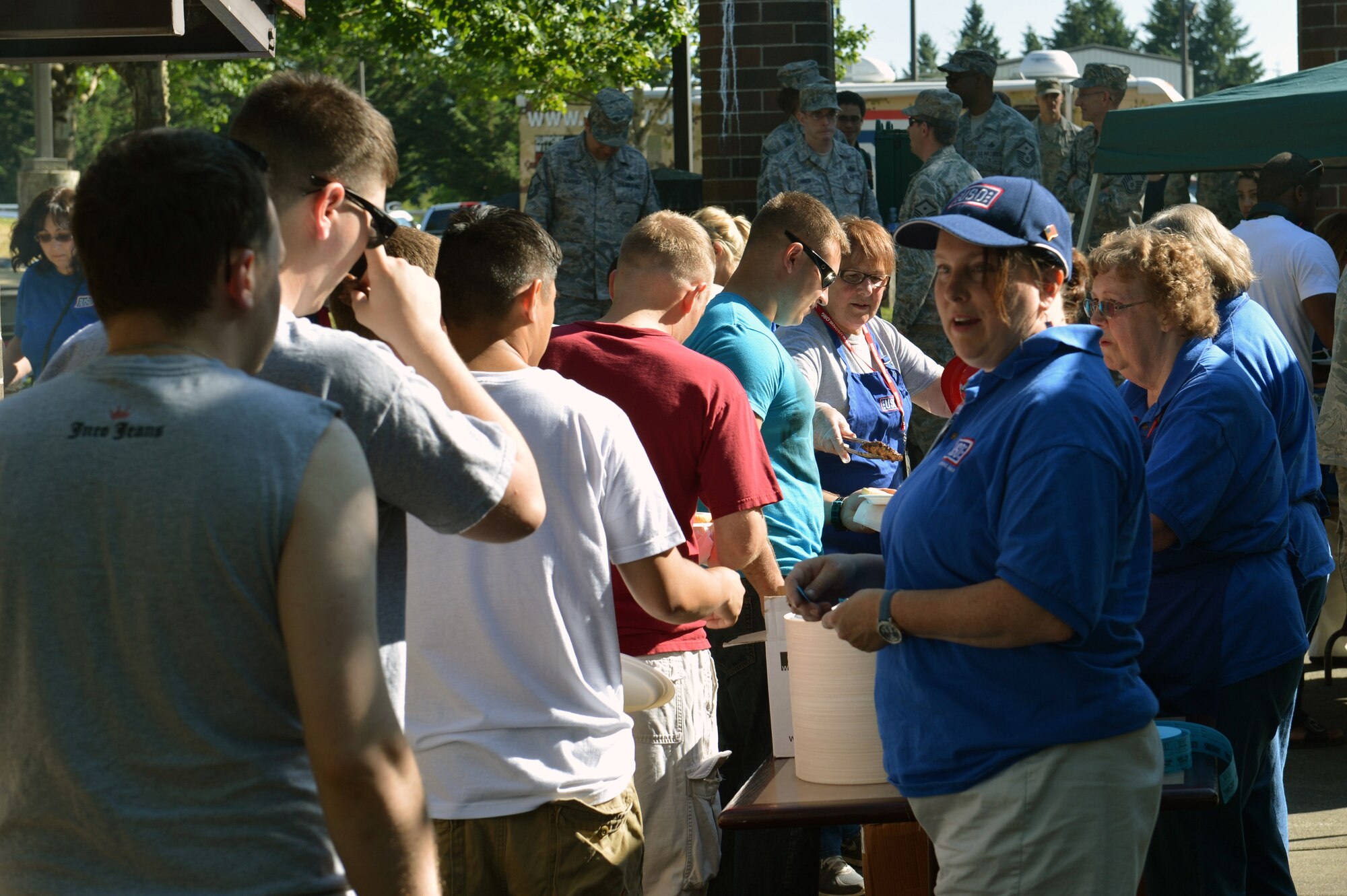 United Service Organization volunteers serve dinner to Team McChord Airmen July 10, 2013 at Joint Base Lewis-McChord, Wash. The USO provided dinner, dessert and live music in the common area of the dormitory buildings for single Airmen. (U.S. Air Force photo/Staff Sgt. Jason Truskowski)
