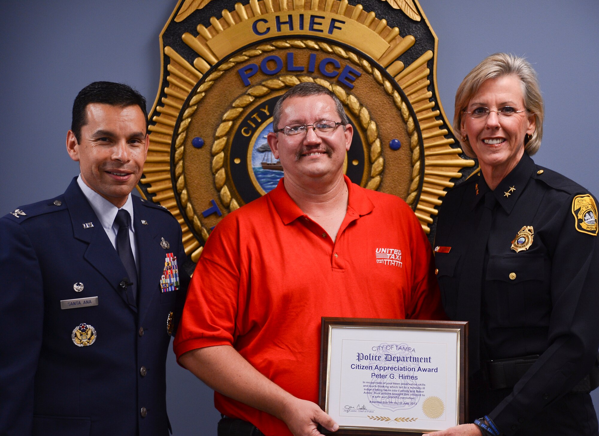 Peter G. Himes, Tampa cab driver, poses with Jane Castor, Tampa Police Chief, and Col. Peter Santa Ana, 6th Mission Support Group commander, after receiving the Citizen's Award at the Tampa Police Department, July 9, 2013. Himes prevented a passenger from reaching MacDill Air Force Base and causing potential harm to its personnel and civilians. (U.S. Air Force Photo by Airman 1st Class Vernon L. Fowler Jr./Released)